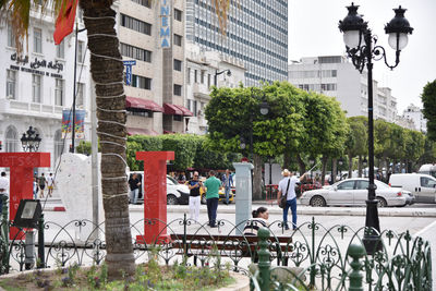 People on street against buildings in city