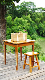 Empty chairs and table against trees in park