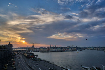 High angle view of river by buildings against sky during sunset