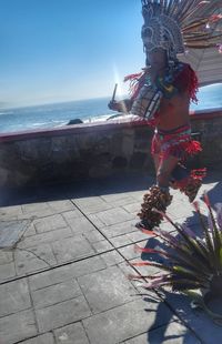 Rear view of woman standing at beach against clear sky