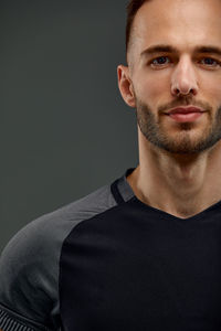 Portrait of young man against black background