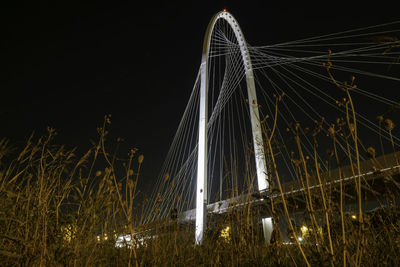 Low angle view of illuminated bridge against sky at night