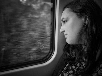 Thoughtful woman looking through train window