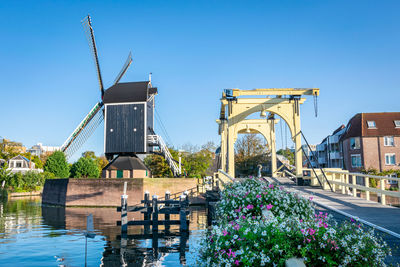 Built structure by water against clear blue sky