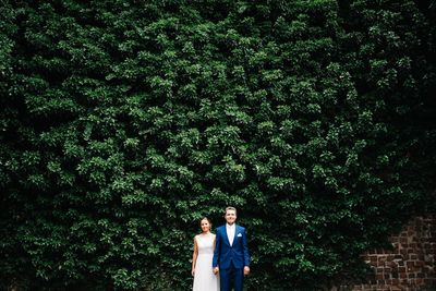 People standing by tree against plants