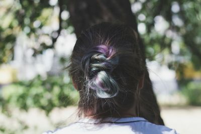 Rear view portrait of woman against purple tree