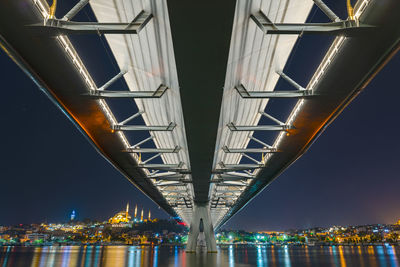 Low angle view of illuminated bridge against sky at night