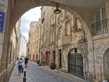 Rear view of people walking on old building