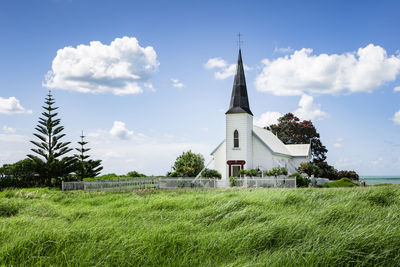 Building on field against sky