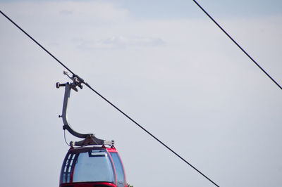 Low angle view of overhead cable car against sky