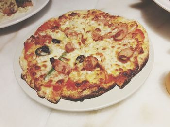 High angle view of fresh pizza served in plate on table