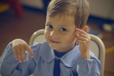 Close-up portrait of boy sitting at home