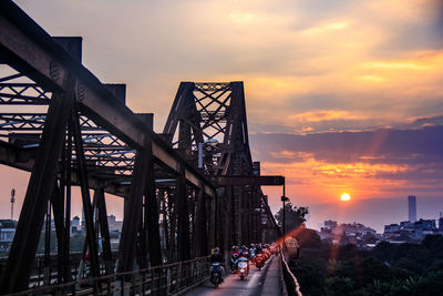 Bridge over city against sky during sunset