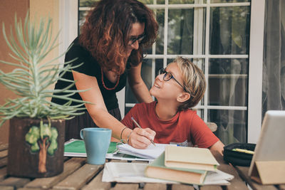 Mother helping boy in study at home