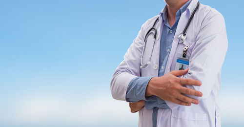 Midsection of man standing against blue background