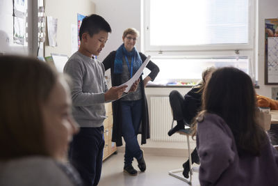 Boy reading in front of class