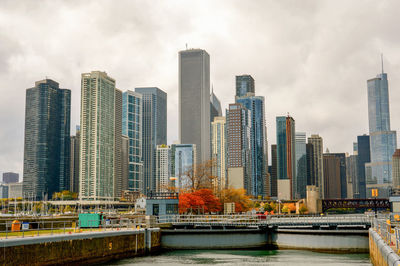 River with tall buildings against clouds