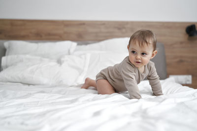 Cute baby boy sleeping on bed at home