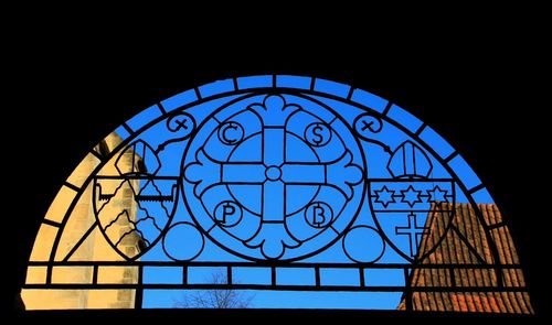 Low angle view of dome against clear blue sky seen through window