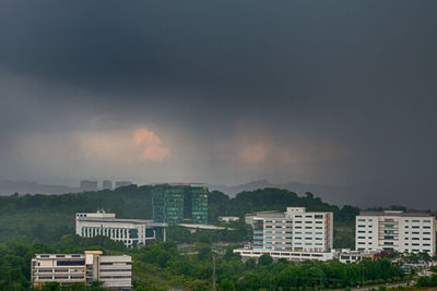 High angle view of buildings against cloudy sky