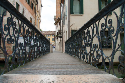 Walkway in city against sky