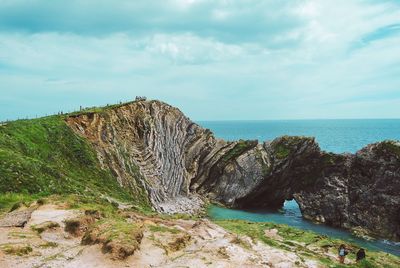 Rock formations by sea against sky