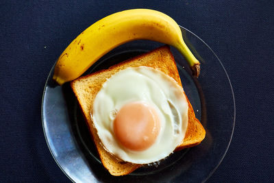 High angle view of bananas and a toast with egg on table