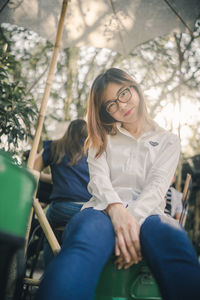 Full length of young woman sitting on seat