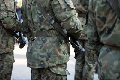 Rear view of soldiers standing in several ranks with weapons.