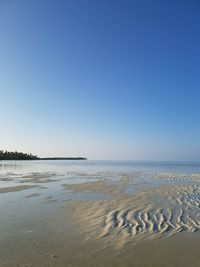 Scenic view of beach against clear blue sky