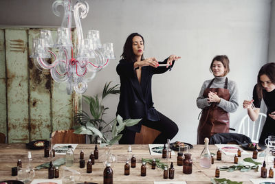 Mid adult woman photographing perfume bottles