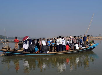 Panoramic view of people in boat against clear sky