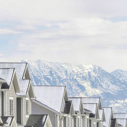 Houses on snowcapped mountain against sky