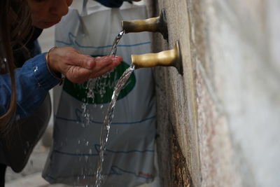 Midsection of woman drinking water at fountain