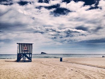 Scenic view of beach against cloudy sky