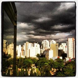 Cityscape against cloudy sky