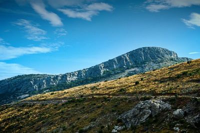 Low angle view of mountain against blue sky