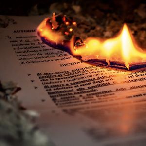 Close-up of lit candles on paper