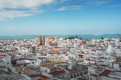 High angle view of townscape by sea against sky