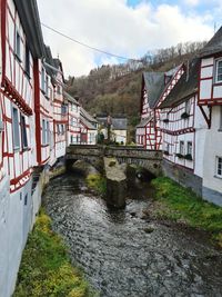 Bridge over river amidst buildings against sky