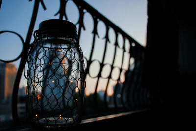 Close-up of railing against sky during sunset