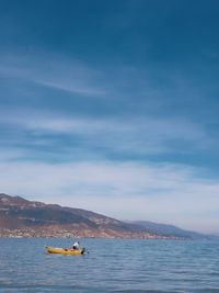 Man on boat in sea against sky