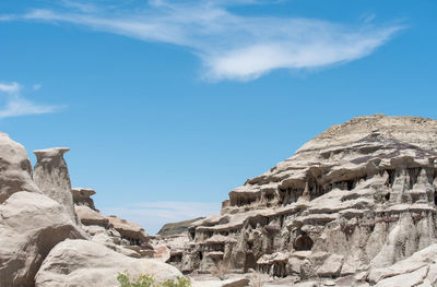 Low angle landscape of grey rock formations and hoodoos at bisti badlands in new mexico