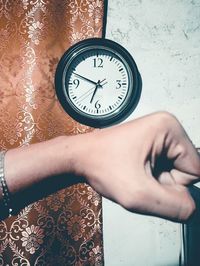 Close-up of hand holding clock