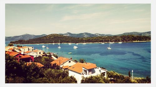 Boats in sea with mountain range in background