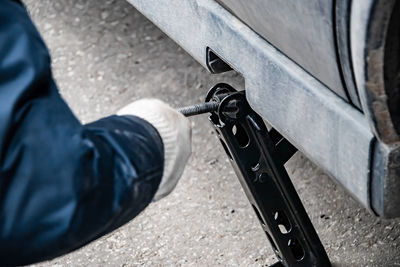 Auto mechanic changes wheel on old car. man changes punctured tire after breakdown 