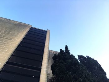 Low angle view of office building against clear blue sky