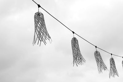 Low angle view of clothes hanging on rope against sky