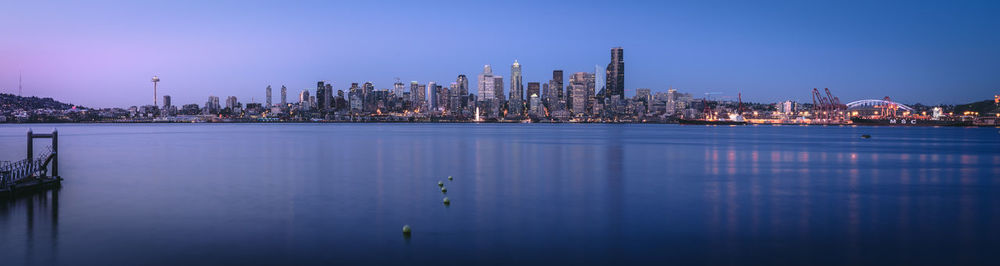 Sea and modern buildings in city at dusk