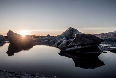 Scenic view of lake against clear sky during sunset